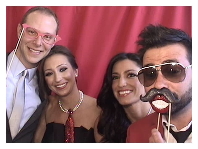 Friends posing with props in modern photobooth
